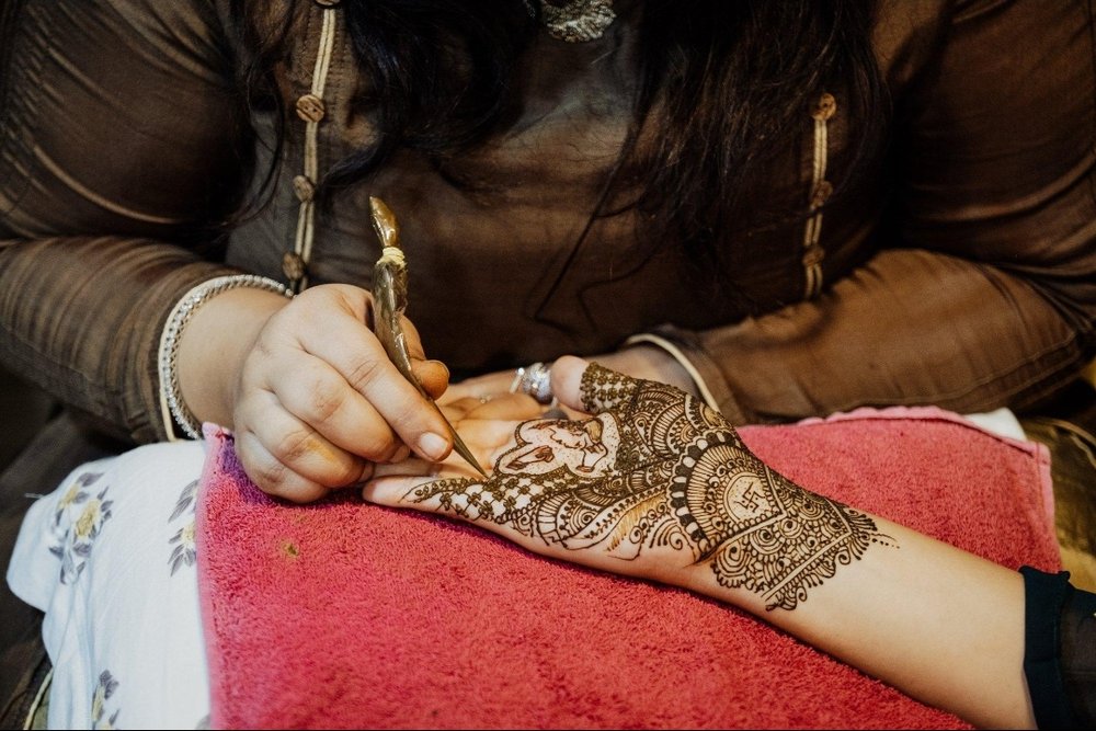 Siraj Mehndi Artist applying henna to a client